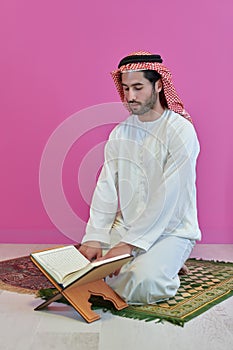 Young muslim man reading Quran during Ramadan