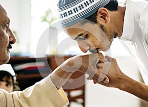 Young Muslim man showing respect to his father