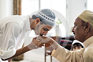 Young Muslim man showing respect to his father photo