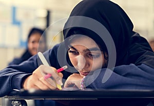 Young Muslim student studying at school