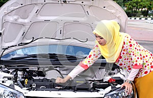 Young muslim woman checking engine