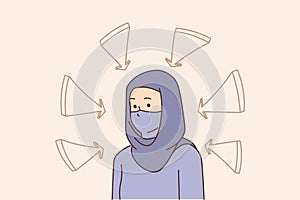 Young muslim woman in hijab with arrows point at her