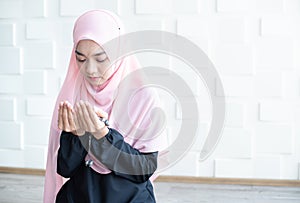 Young muslim woman holding prayer beads over mosque background