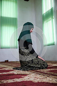 Young Muslim woman praying in the mosque