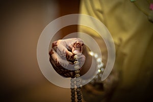 Young Muslim woman praying with praying beats and on hands mehndi design with space for text