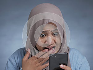 Young Muslim Woman Shocked Expression, Looking at Her Phone