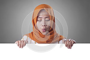 Young Muslim Woman Smiling Behind Blank White Board