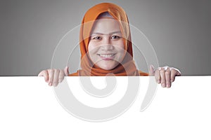 Young Muslim Woman Smiling Behind Blank White Board