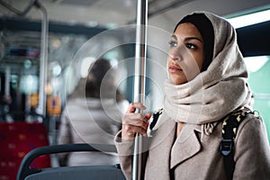 Young muslim woman traveling by public bus.
