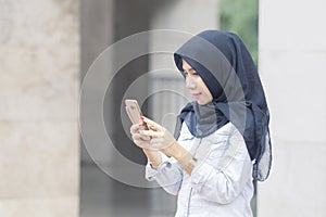 Young Muslim woman using a mobile phone