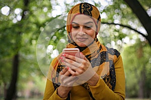 Young Muslim woman using smart phone.