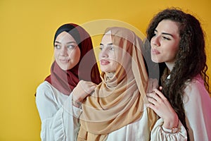 Young muslim women posing on yellow background