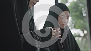 Young Muslim women praying for the blessing of Allah.