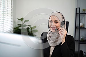 Young muslim women wearing hijab telemarketing or call center agent with headset working on support hotline at office