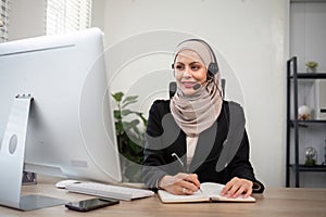 Young muslim women wearing hijab telemarketing or call center agent with headset working on support hotline at office