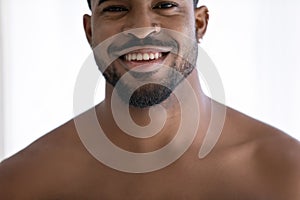 Young naked african ethnicity man showing healthy white toothy smile.