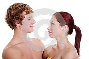 Young naked couple looking at each other.