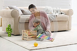 Young nanny and cute little baby playing with toys photo