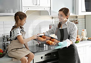 Young nanny with cute little girl cooking together photo