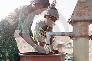 Young Native African Infant Saving Crisp Water for a lack of water symbol