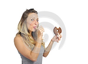 Young naughty woman eating chocolate donut happy guilty for unhealthy nutrition