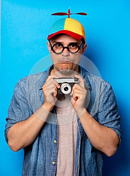 Young nerd man with noob hat holding camera