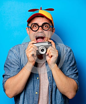 Young nerd man with noob hat holding camera photo