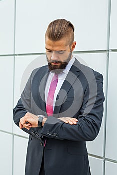 Young nervous bussinessman checking time while waiting for a meeting