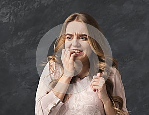 Young nervous woman biting her nails