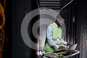 Young network technician repairing servers in data center