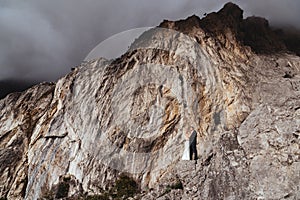 Young newly wed couple, bride and groom kissing, hugging on perfect view of mountains