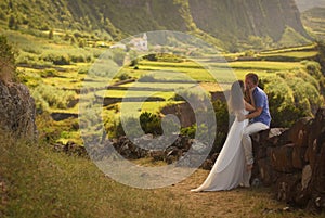 Young newly wedded kissing couple in honneymoon on Flores island, Azores photo