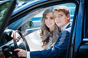 Young newlyweds inside a car