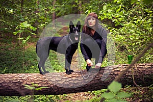 Young nice woman with dog in the forest