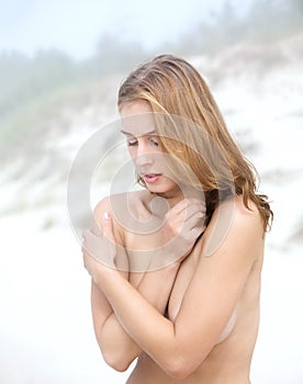 Young nude woman on sandy beach