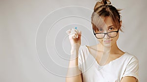 Young nurd woman in glasses nervously holding pen thinking of something