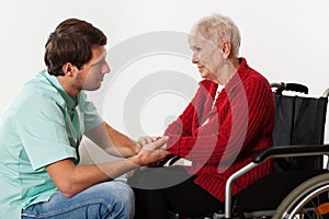 Young nurse assisting disabled lady photo