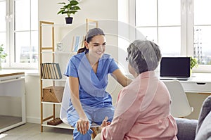 Young nurse or doctor talking to senior woman, trying to support and reassure her