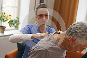 Young nurse doing exercise with senior man.