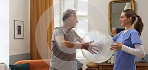 Young nurse doing exercise with senior man.