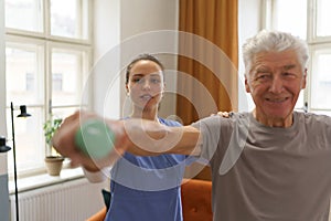 Young nurse doing exercise with senior man.