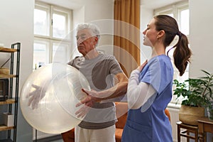 Young nurse doing exercise with senior man.