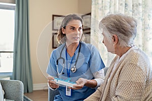 Nurse explaining medicine dosage to senior woman at nursing home photo