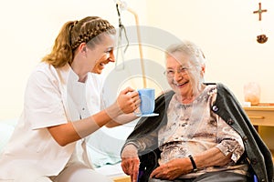 Young nurse and female senior in nursing home photo