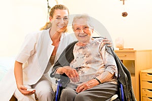 Young nurse and female senior in nursing home photo