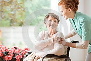 Young nurse helping an elderly woman in a wheelchair. Nursing ho