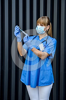 Young nurse holding vials medication and injection needle. Medical doctor picking up medication into syringe