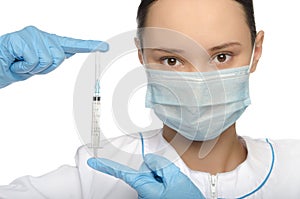 Young nurse in mask and gloves holding a syringe