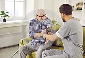 Nurse measure blood pressure of a sick senior mature male patient at home.