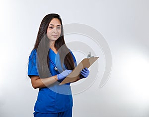 Young Nurse in Scrubs Points At Her Clipboard